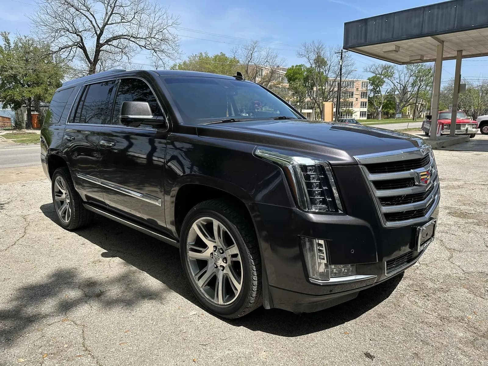 Black Cadillac Escalade with window tint installed, outside the Shade Customs shop in Georgetown, Texas