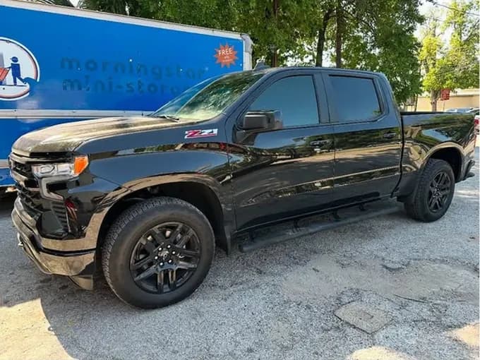 Black Chevrolet Silverado Z71 with window tint installed, outside the Shade Customs shop in Georgetown, Texas