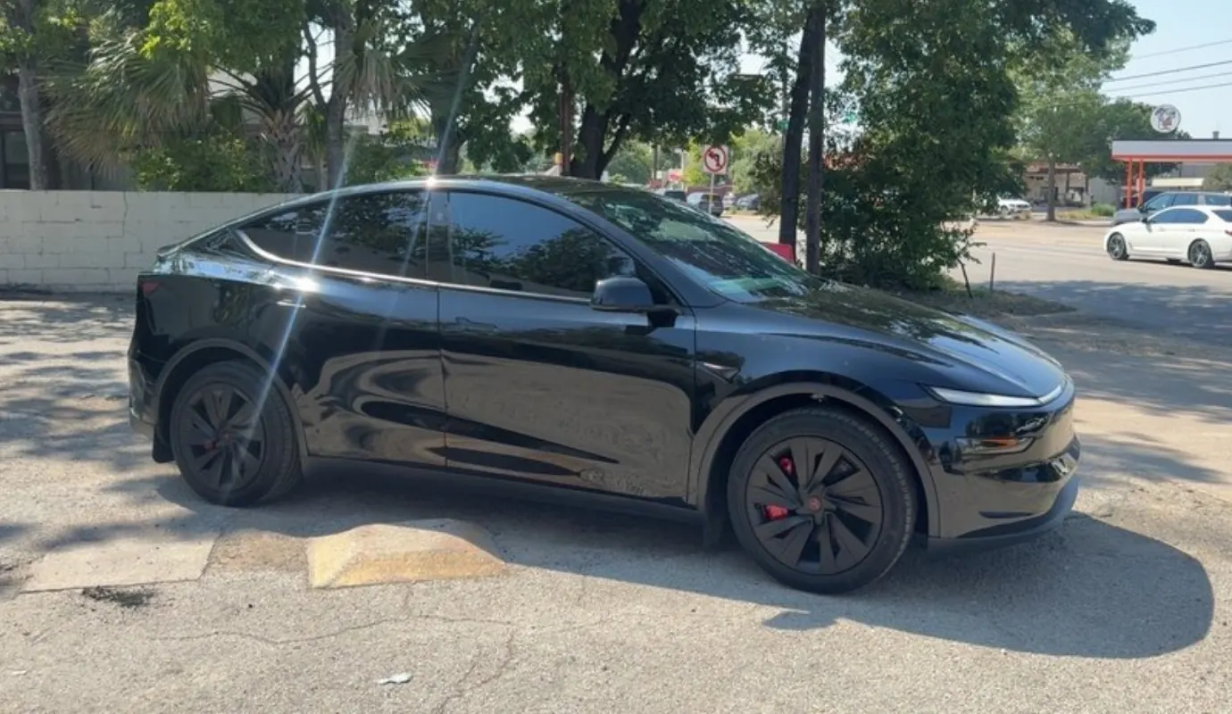 Black Tesla Model Y with window tint installed, outside the Shade Customs shop in Georgetown, Texas