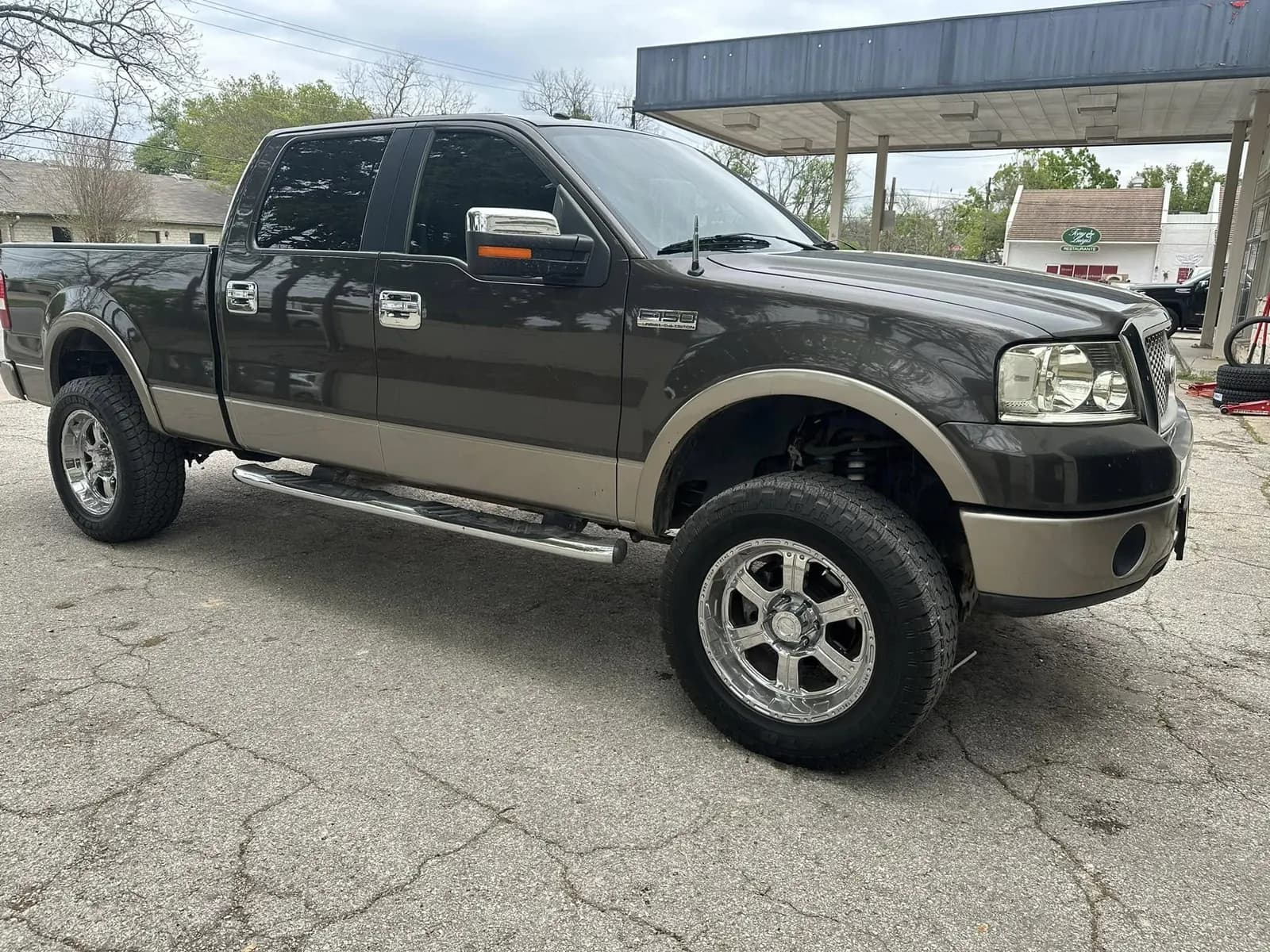 Brown Ford F-150 with window tint installed, outside the Shade Customs shop in Georgetown, Texas