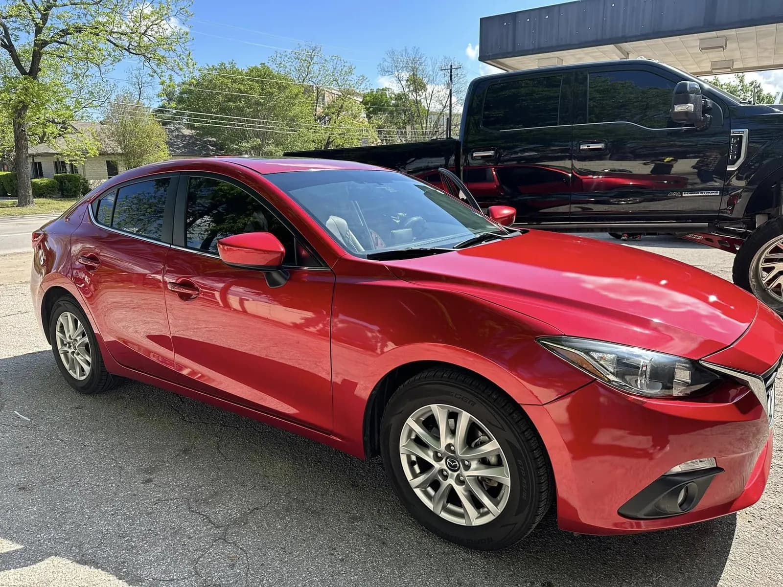 Red Mazda 6 with window tint installed, outside the Shade Customs shop in Georgetown, Texas