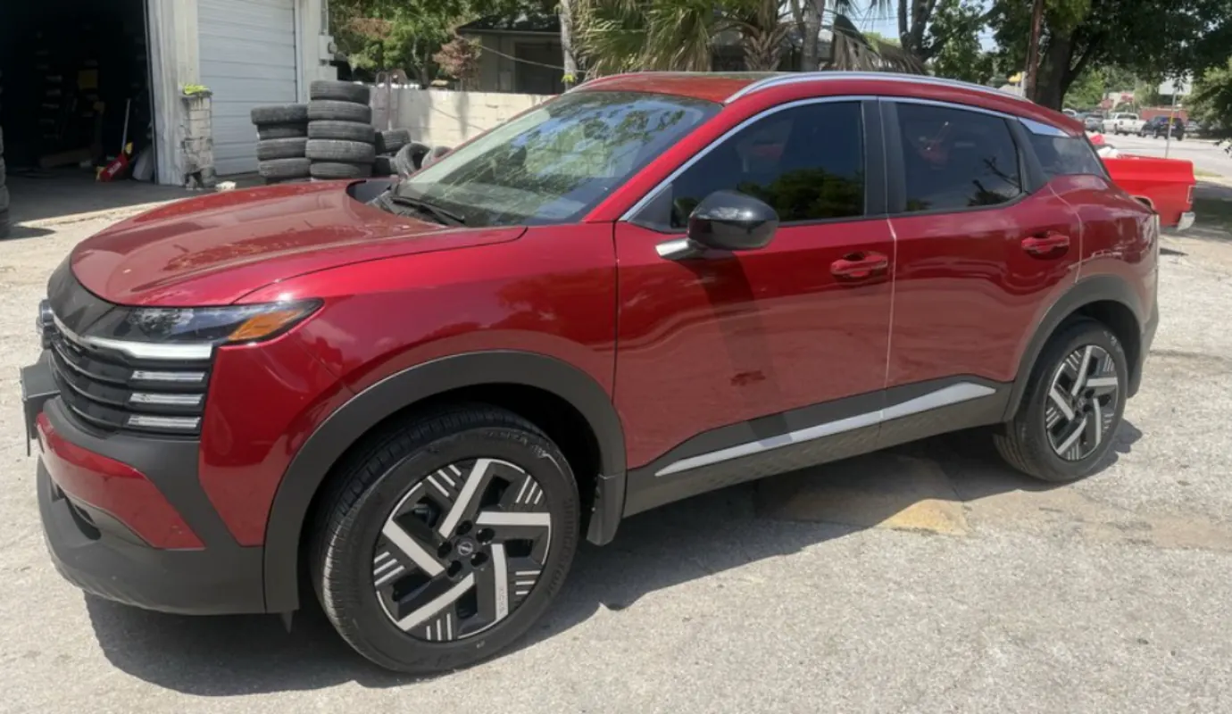 Red Nissan Murano with window tint installed, outside the Shade Customs shop in Georgetown, Texas