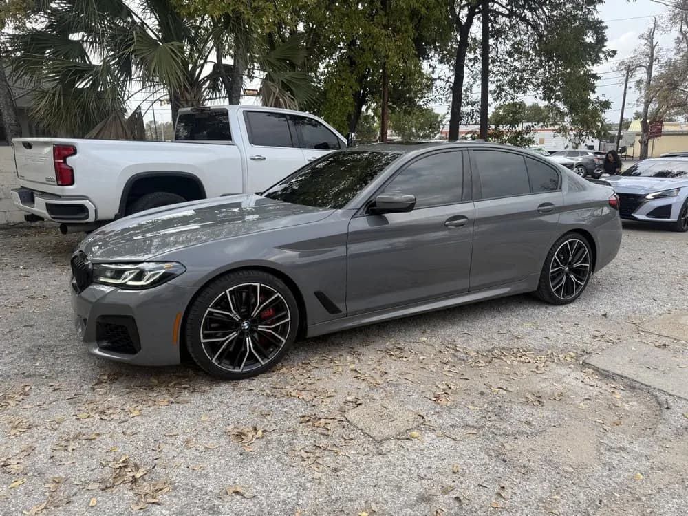 Grey BMW M5 with window tint installed, outside the Shade Customs shop in Georgetown, Texas