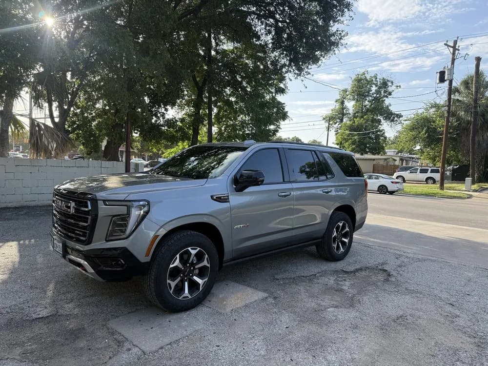 Silver GMC Yukon with window tint installed, outside the Shade Customs shop in Georgetown, Texas