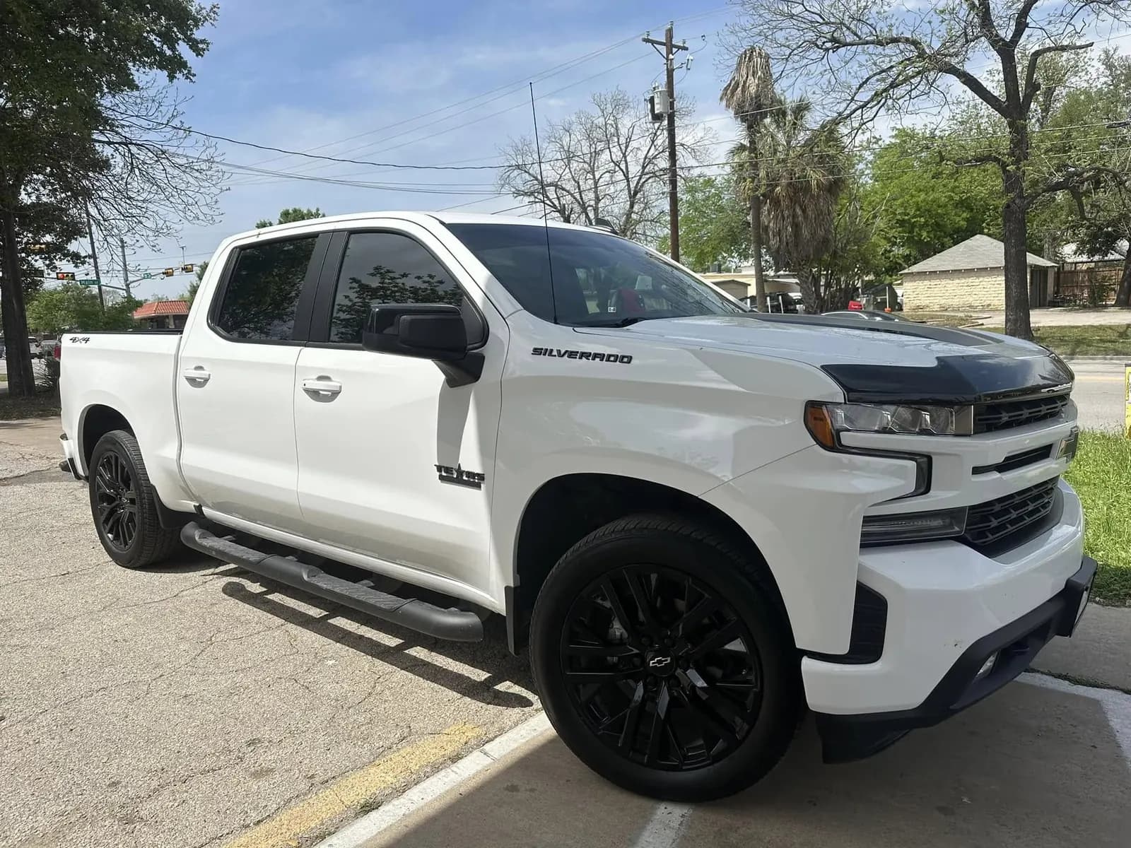 White Chevrolet Silverado RST with window tint installed, outside the Shade Customs shop in Georgetown, Texas