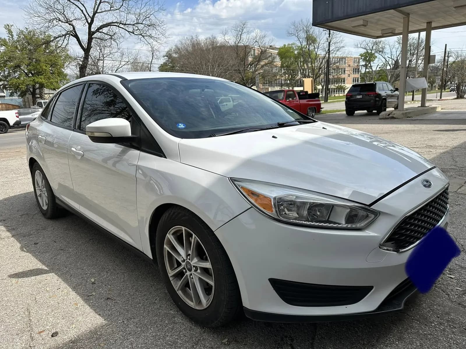 White Ford Focus with window tint installed, outside the Shade Customs shop in Georgetown, Texas