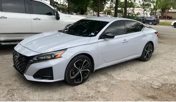 White Nissan Altima with window tint installed, outside the Shade Customs shop in Georgetown, Texas